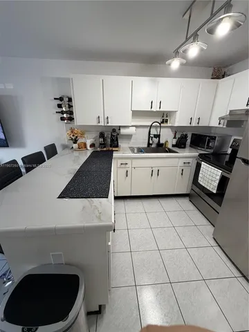 a kitchen with granite countertop white cabinets and white appliances