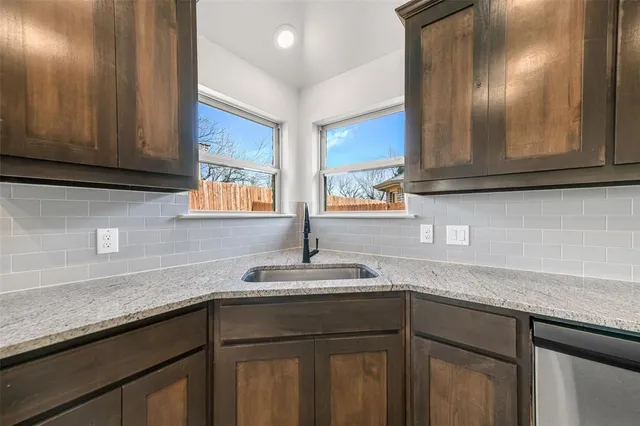 a kitchen with granite countertop cabinets sink and window