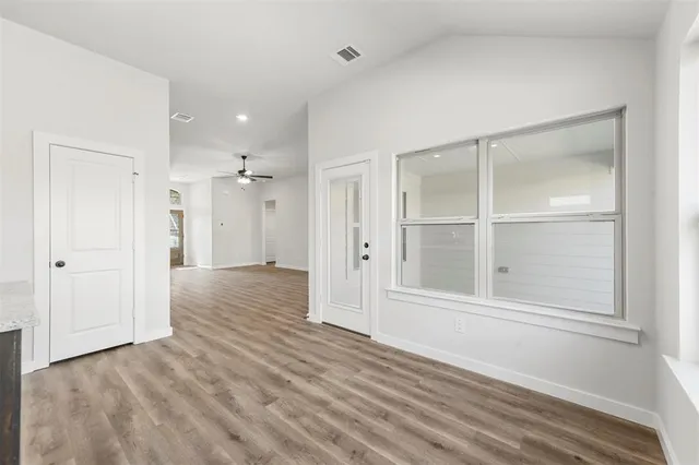 a view of empty room with wooden floor and cabinet