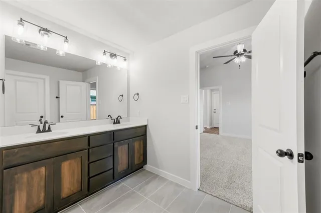 a spacious bathroom with a double vanity sink a mirror and a shower