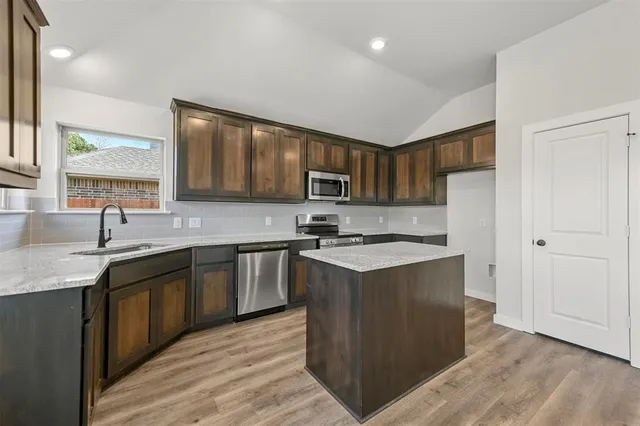 a kitchen with stainless steel appliances granite countertop a sink stove and refrigerator