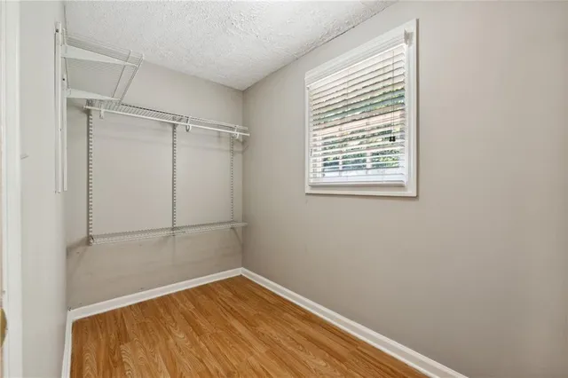 a view of a small space with wooden floor and a window