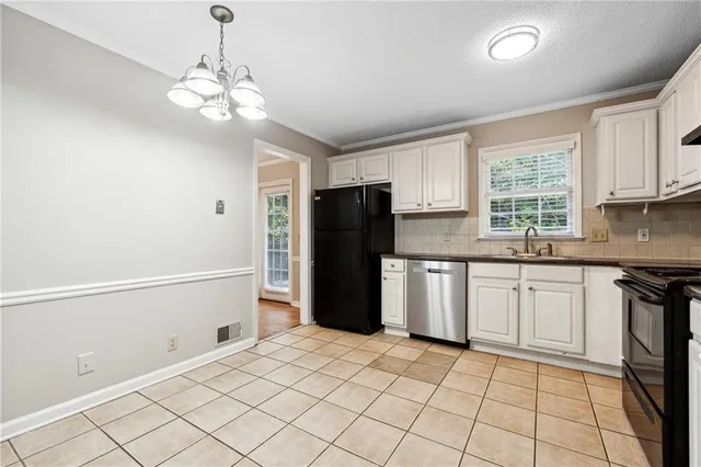 a kitchen with a refrigerator a stove top oven and a window