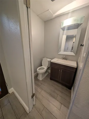 a bathroom with a toilet a sink a mirror and vanity