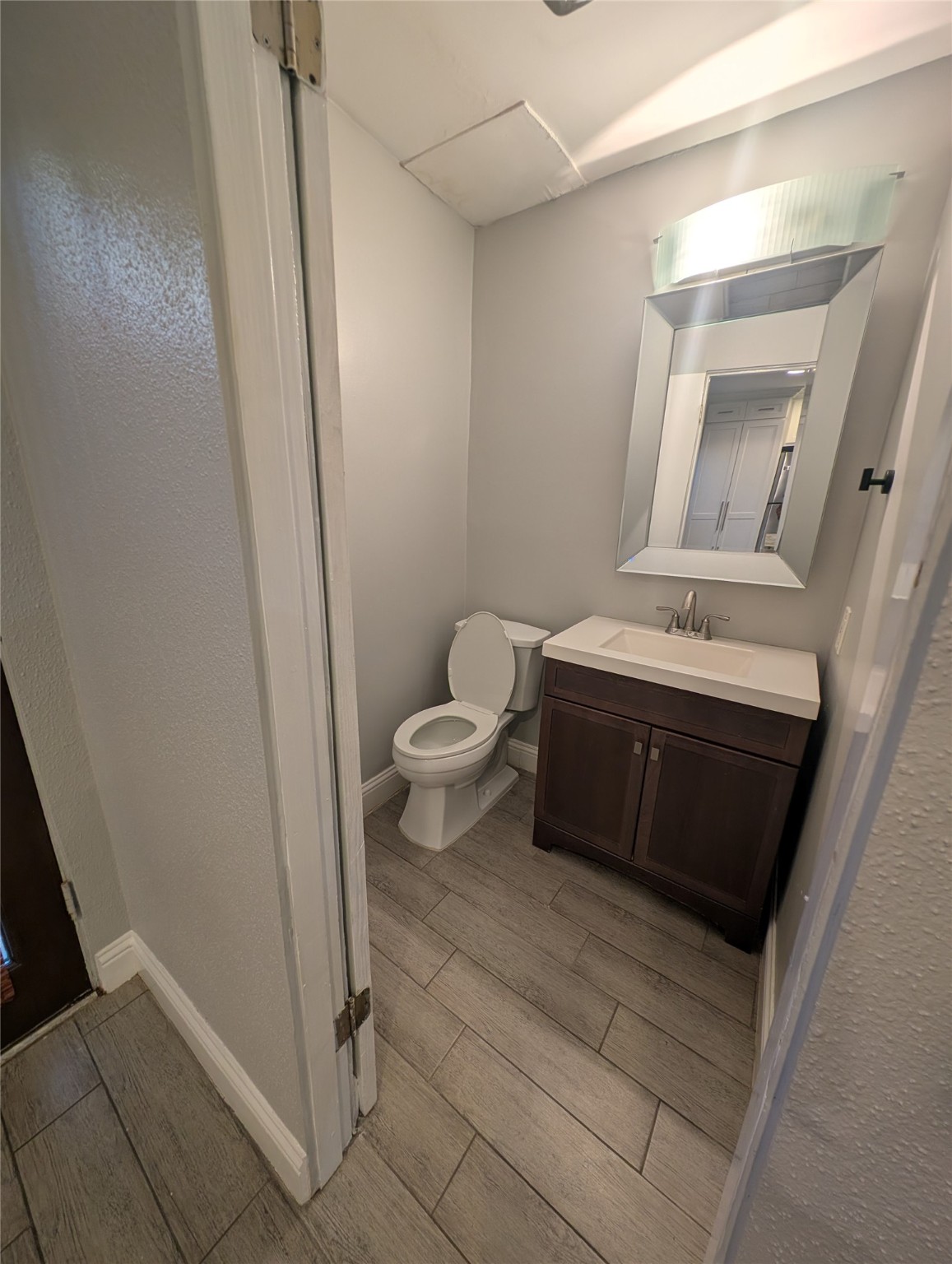 2503 McCue Road, Unit 12 Houston, TX 77056 - Photo 18 of 22 a bathroom with a toilet a sink a mirror and vanity