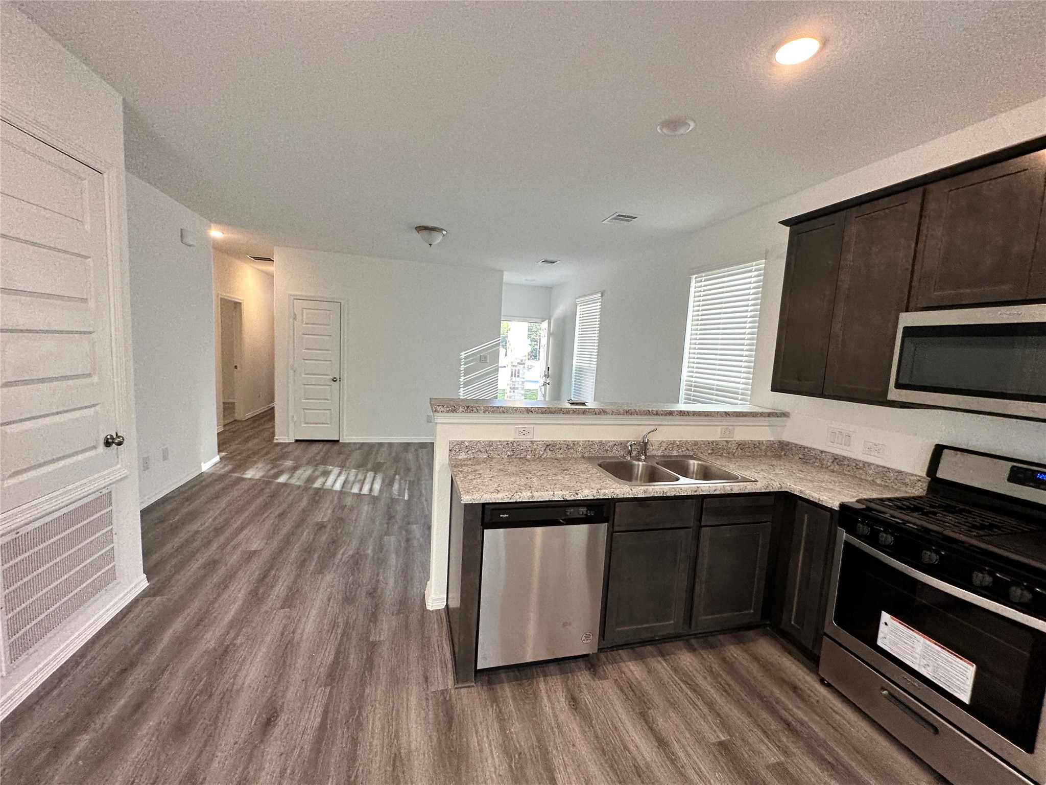 16504 Moss Lane Porter, TX 77365 - Photo 7 of 16 a kitchen with stainless steel appliances granite countertop a stove and a sink
