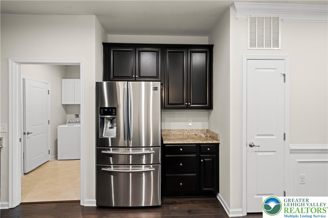 4758 Rafi Road Easton, PA 18045 - Photo 10 of 55 A well-appointed corner pantry with dark cabinetry and a stainless steel refrigerator anchors this inviting kitchen space.
