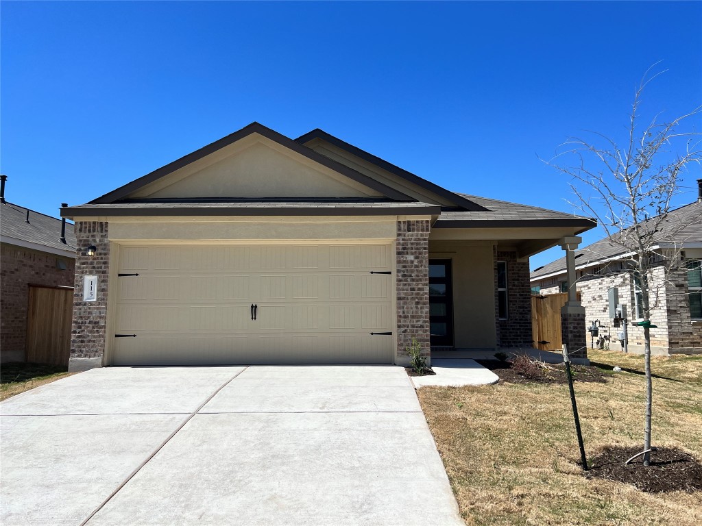 View of front of house featuring brick siding, an attached garage, and concrete driveway