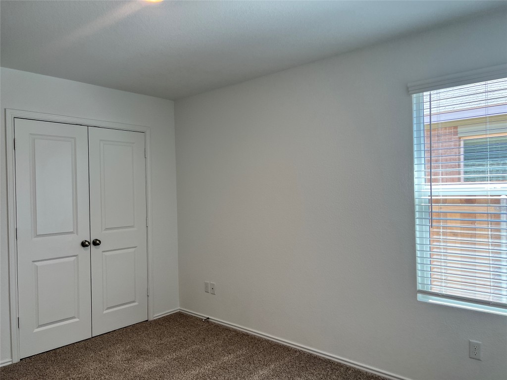 115 Canley Loop Hutto, TX 78634 - Photo 12 of 18 Unfurnished bedroom featuring dark colored carpet and a closet