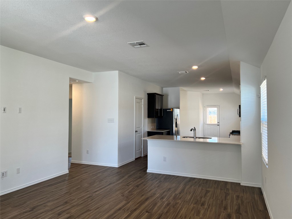 115 Canley Loop Hutto, TX 78634 - Photo 18 of 18 Kitchen featuring a peninsula, recessed lighting, dark wood-type flooring, dark cabinetry, and open floor plan