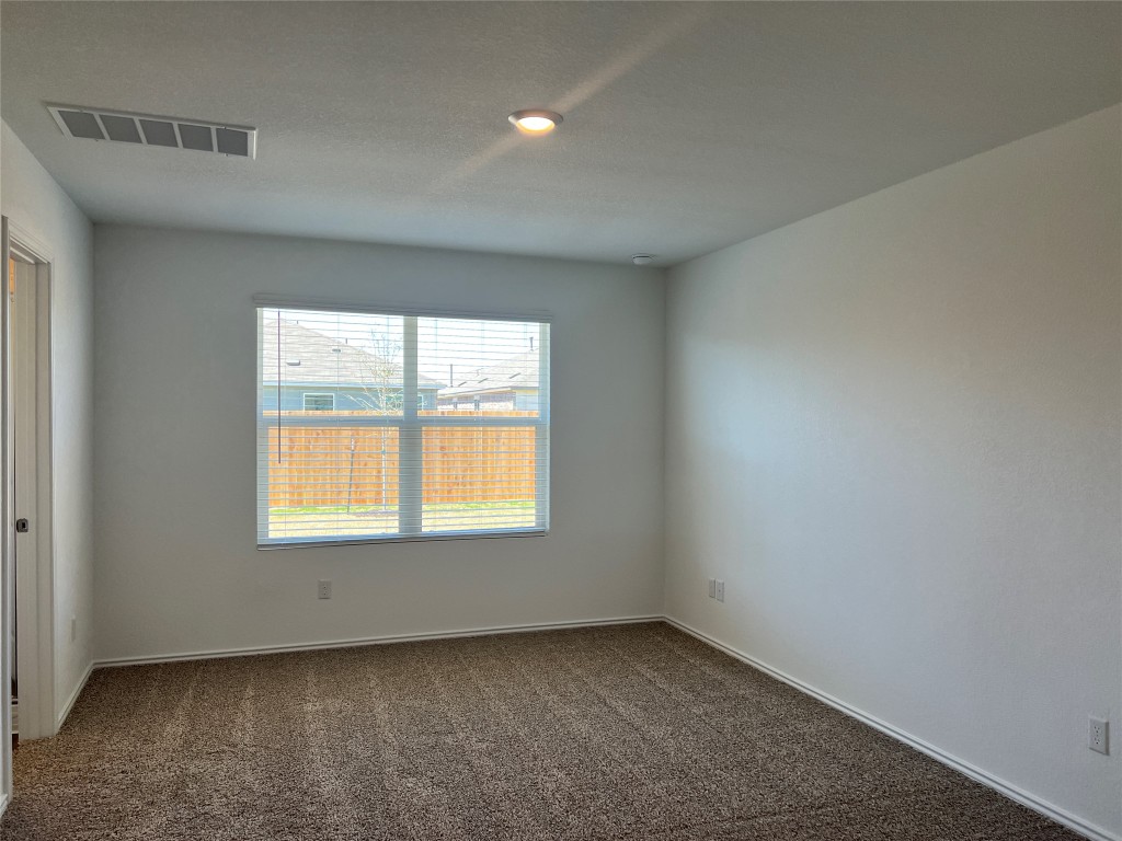 115 Canley Loop Hutto, TX 78634 - Photo 5 of 18 Spare room with dark carpet and a textured ceiling