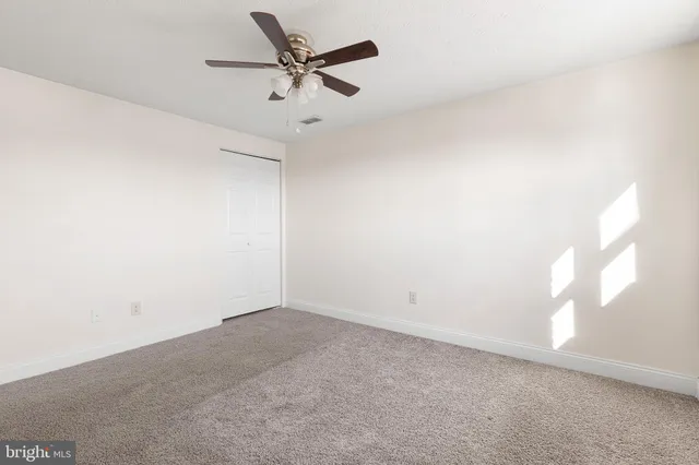 an empty room with a window and a fan
