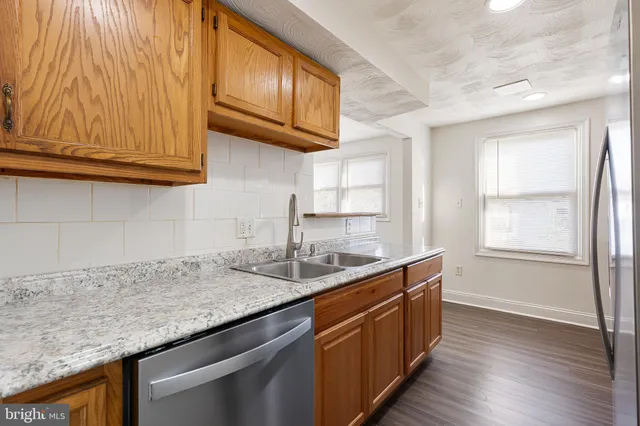 a kitchen with granite countertop stainless steel appliances a sink and cabinets