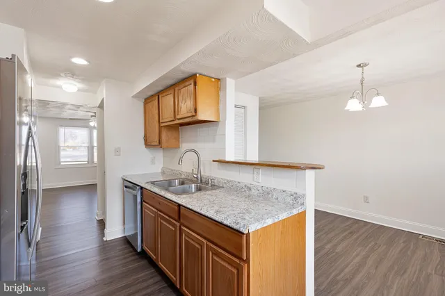 a kitchen with stainless steel appliances granite countertop a sink and wooden floor