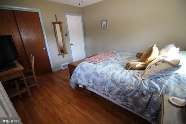 a bedroom with a bed and wooden floor