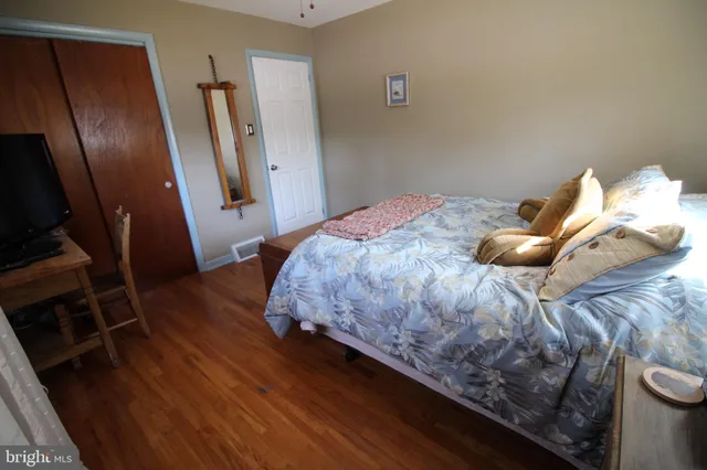 a bedroom with a bed and wooden floor