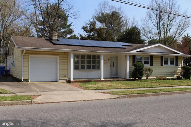 a view of a house with a patio and a yard