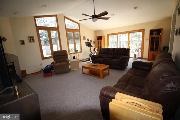a living room with furniture ceiling fan and a window