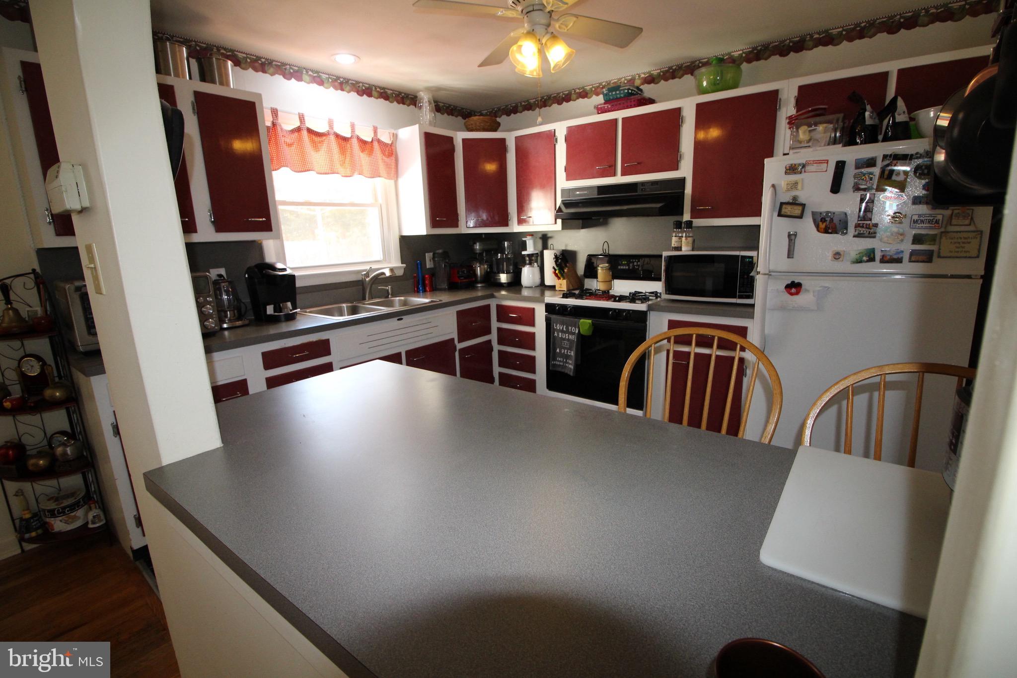 112 Harvard Road Glassboro, NJ 08028 - Photo 8 of 24 a kitchen with stainless steel appliances a dining table chairs a sink and a stove