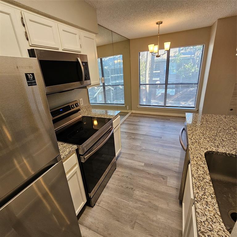 5750 Phoenix Drive, Unit 15 Dallas, TX 75231 - Photo 11 of 23 a kitchen with granite countertop a stove and a microwave