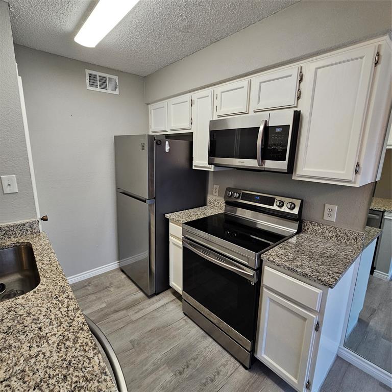 5750 Phoenix Drive, Unit 15 Dallas, TX 75231 - Photo 12 of 23 a kitchen with a stove microwave and refrigerator