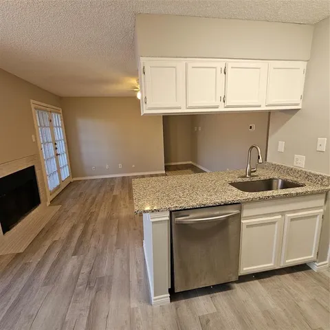 a kitchen with granite countertop wood cabinets stainless steel appliances and a sink