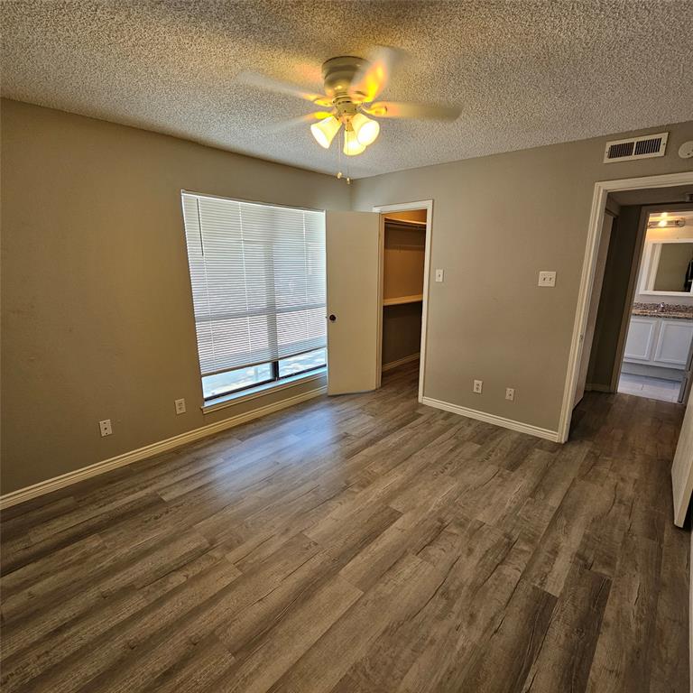 5750 Phoenix Drive, Unit 15 Dallas, TX 75231 - Photo 21 of 23 an empty room with wooden floor and door