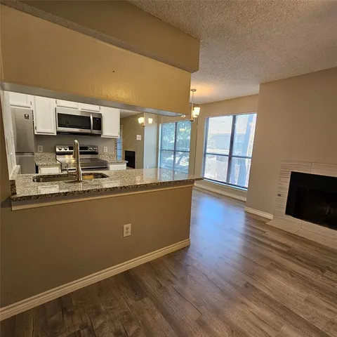 a living room with stainless steel appliances kitchen island wooden floor and view living room