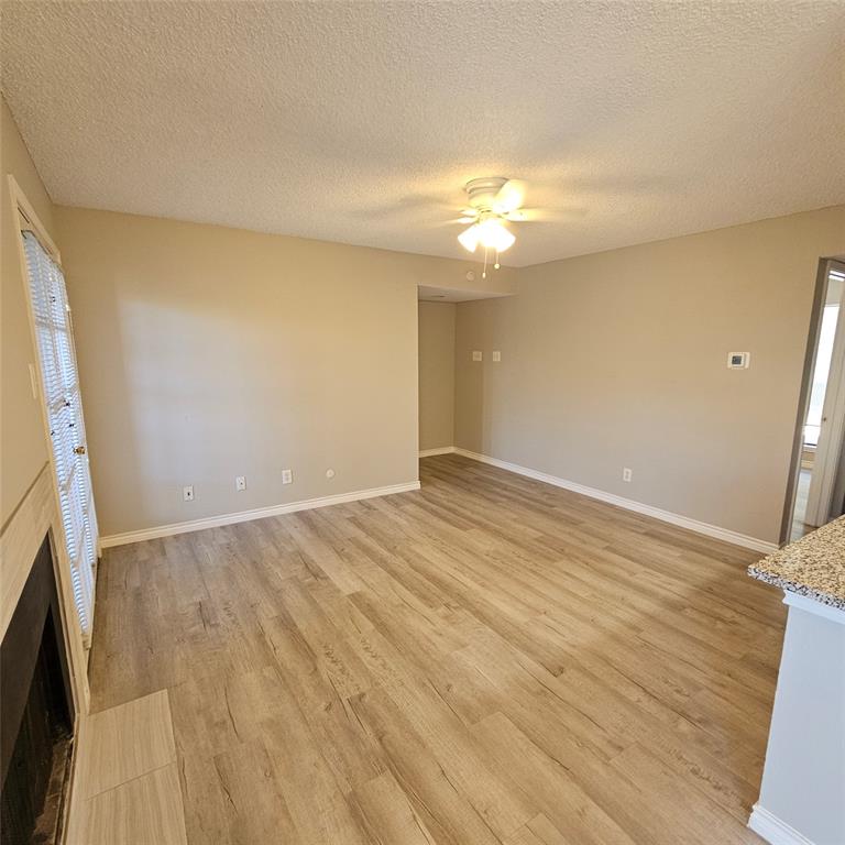 5750 Phoenix Drive, Unit 15 Dallas, TX 75231 - Photo 4 of 23 an empty room with wooden floor and fan