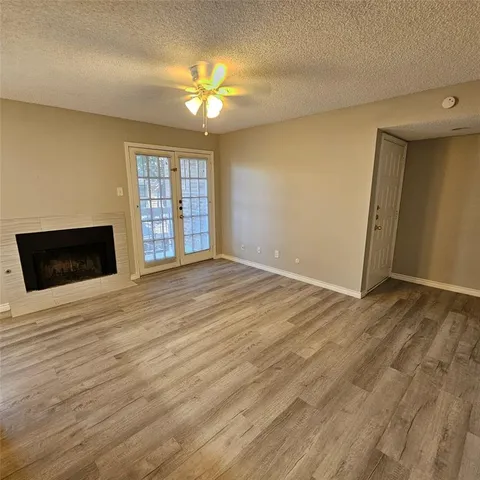 a view of an empty room with window and wooden floor