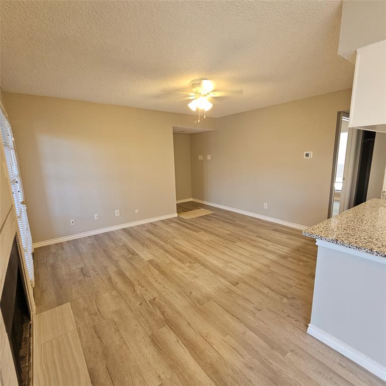 5750 Phoenix Drive, Unit 15 Dallas, TX 75231 - Photo 8 of 23 an empty room with wooden floor and a bathroom