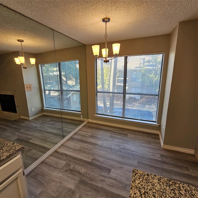 5750 Phoenix Drive, Unit 15 Dallas, TX 75231 - Photo 10 of 23 a view of an empty room with wooden floor and a window