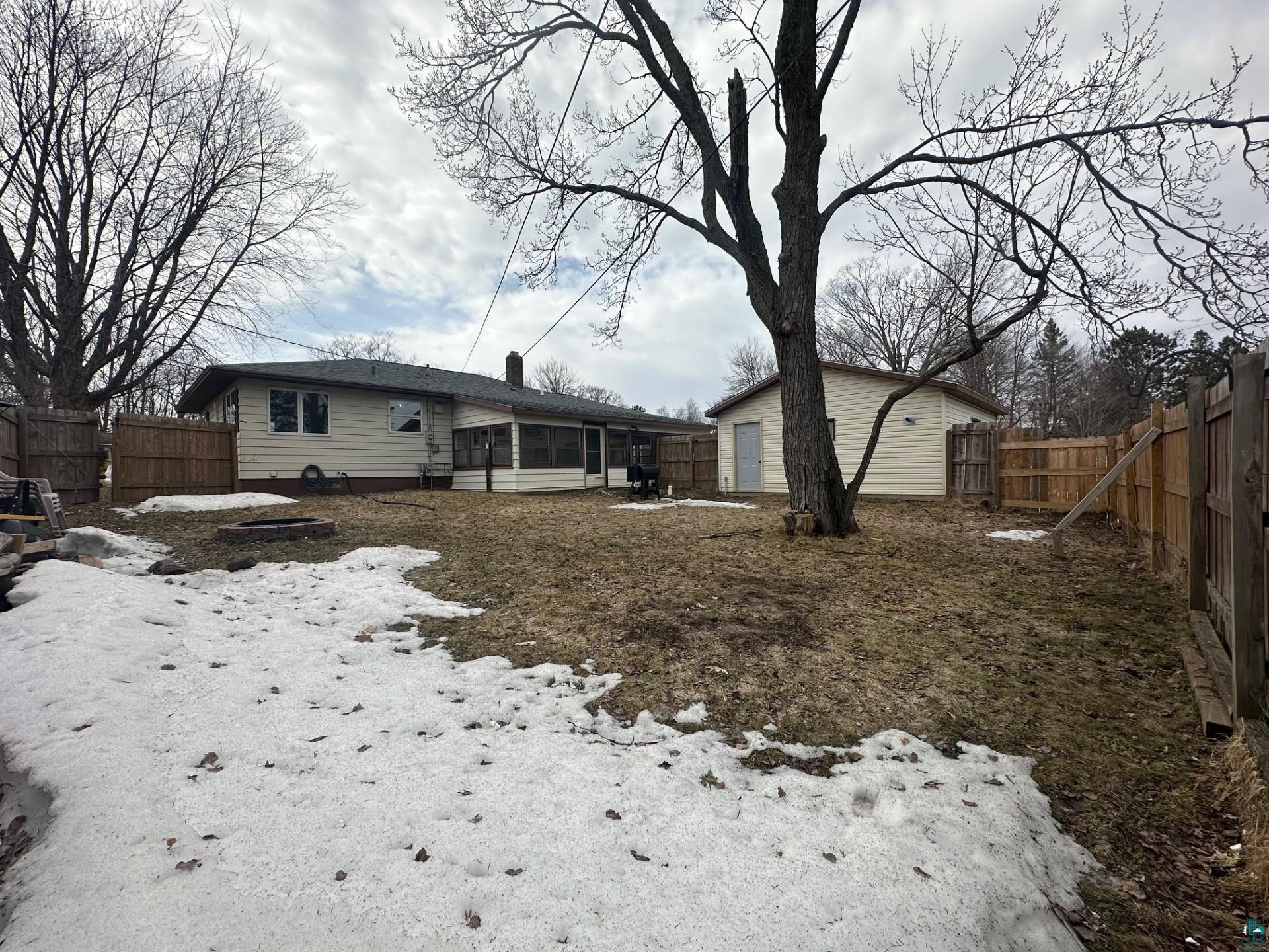 702 27th Street Cloquet, MN 55720 - Photo 21 of 25 Snow covered property with a sunroom, a fenced backyard, and a chimney