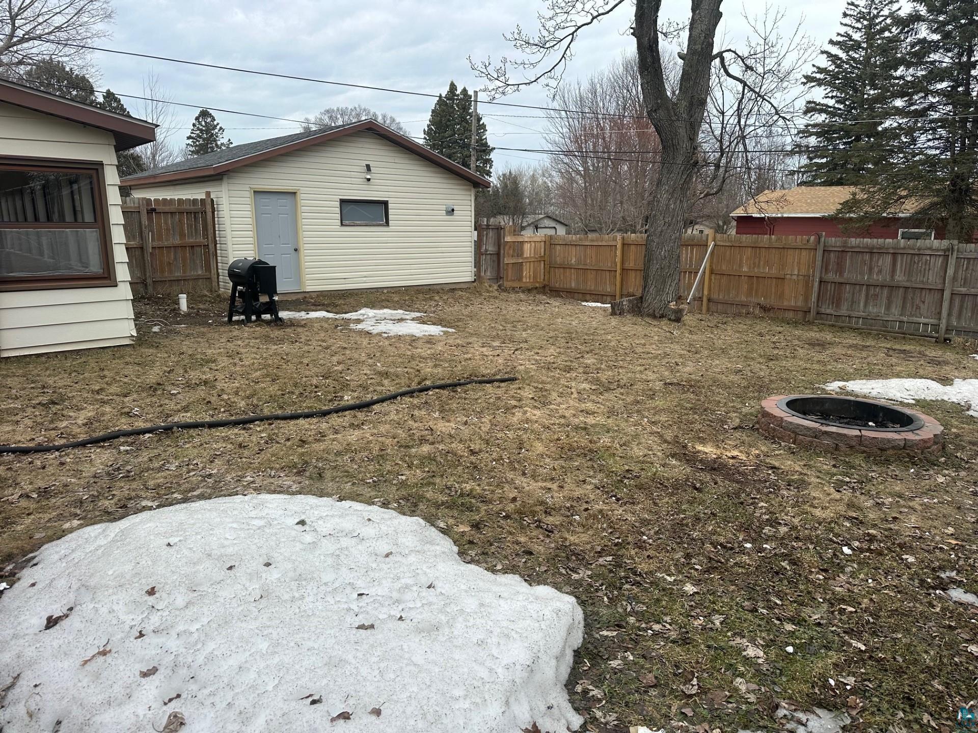 702 27th Street Cloquet, MN 55720 - Photo 22 of 25 Fenced backyard featuring a fire pit