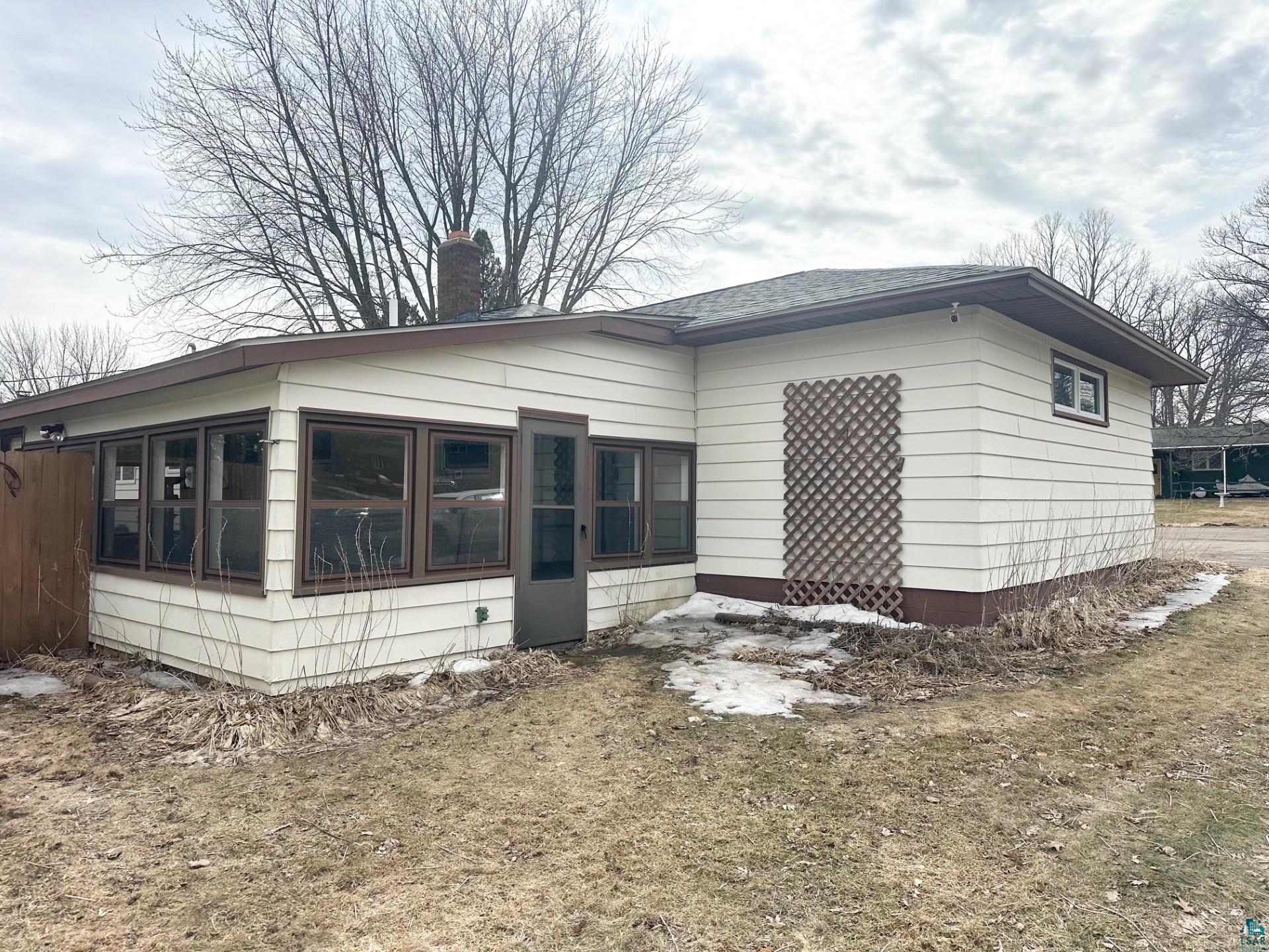 702 27th Street Cloquet, MN 55720 - Photo 25 of 25 View of property exterior featuring a sunroom and a chimney