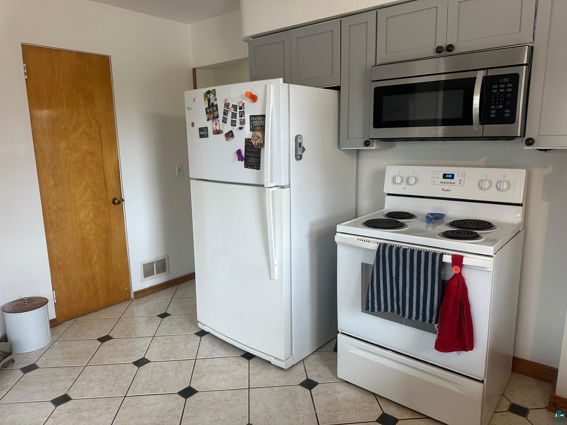 702 27th Street Cloquet, MN 55720 - Photo 5 of 25 Kitchen with white appliances and gray cabinets
