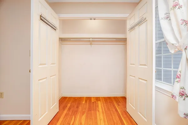 a view of a bedroom with wooden floor and a window