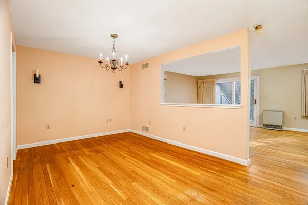a view of a room with wooden floor a ceiling fan and window