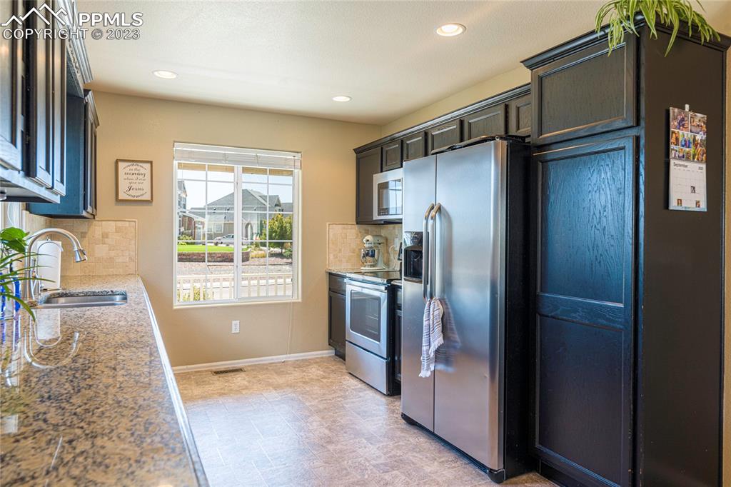 12713 Pine Valley Circle Peyton, CO 80831 - Photo 3 of 26 a kitchen with a refrigerator and a sink