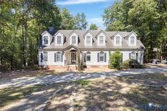 a view of a white house with large windows and a small yard