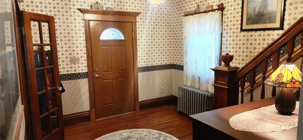 a view of a hallway with wooden floor and staircase