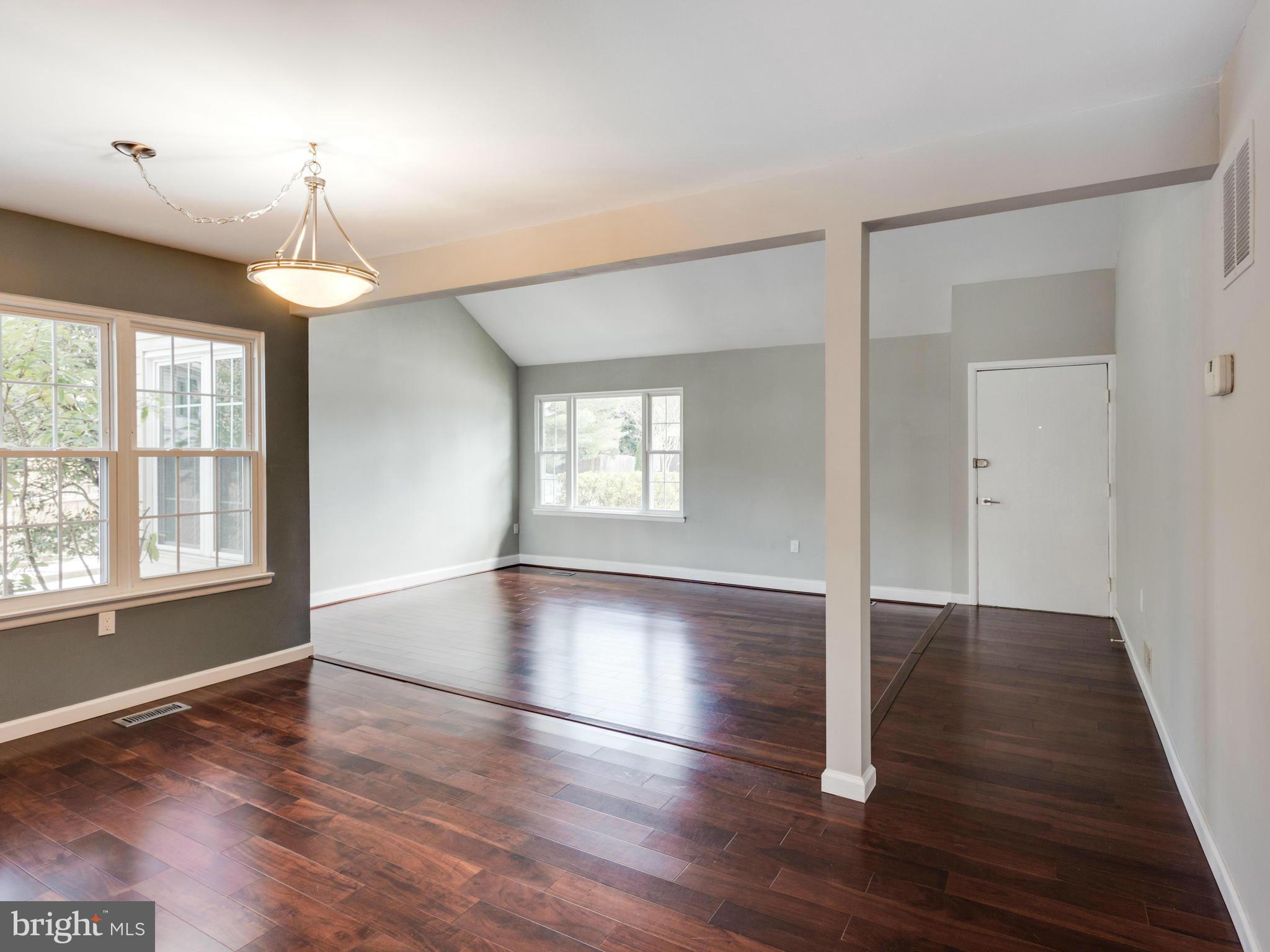 7604 Chancellor Way Springfield, VA 22153 - Photo 2 of 30 an empty room with wooden floor chandelier and windows
