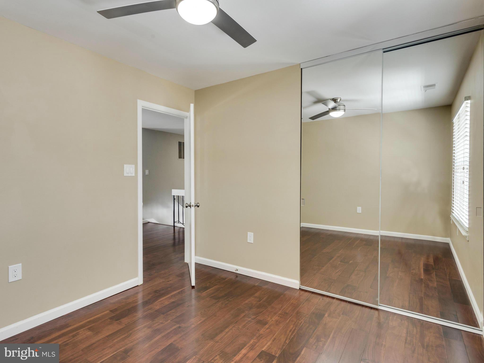 7604 Chancellor Way Springfield, VA 22153 - Photo 20 of 30 an empty room with wooden floor mirror and windows