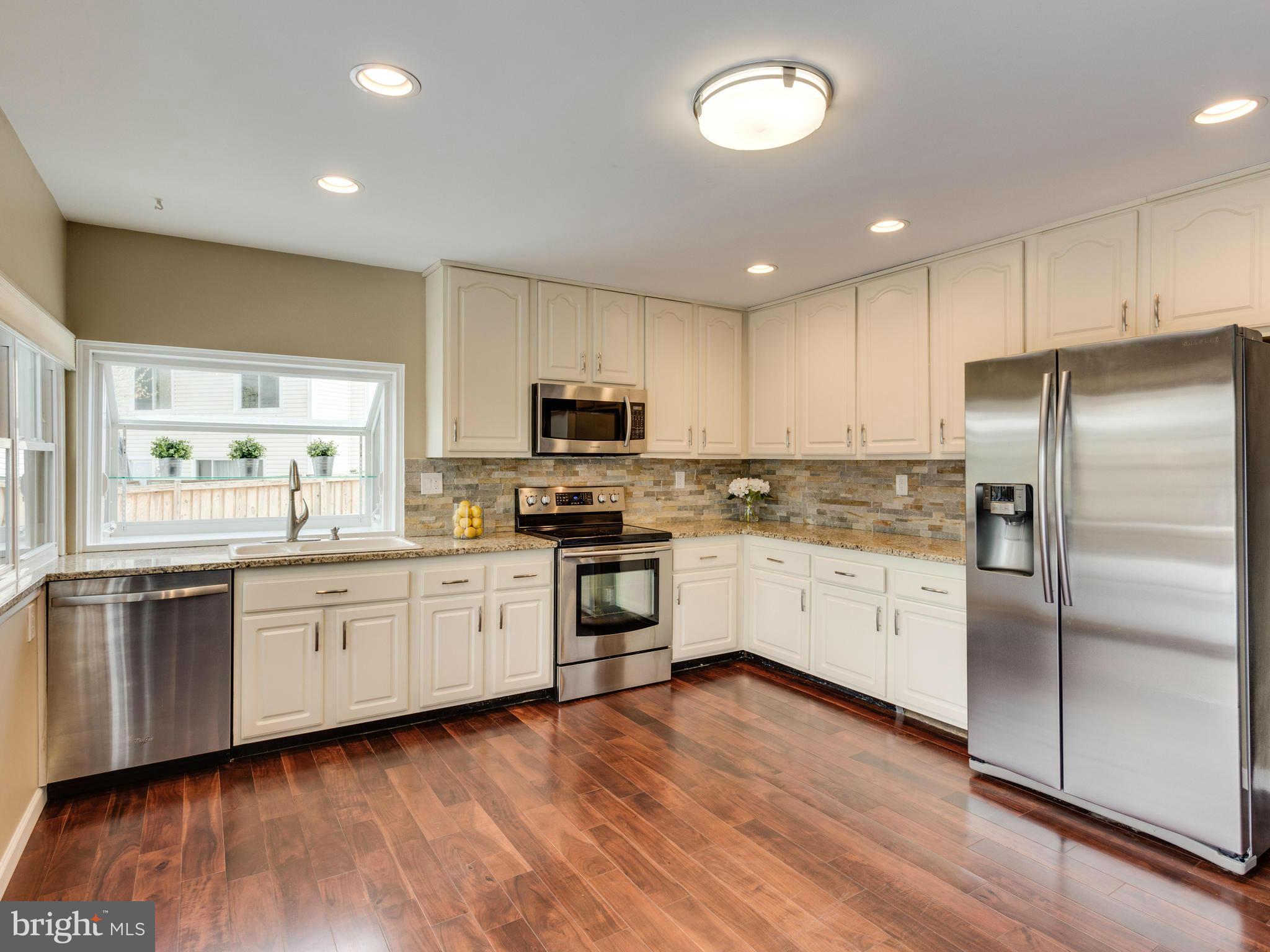 7604 Chancellor Way Springfield, VA 22153 - Photo 5 of 30 a kitchen with granite countertop white cabinets and stainless steel appliances
