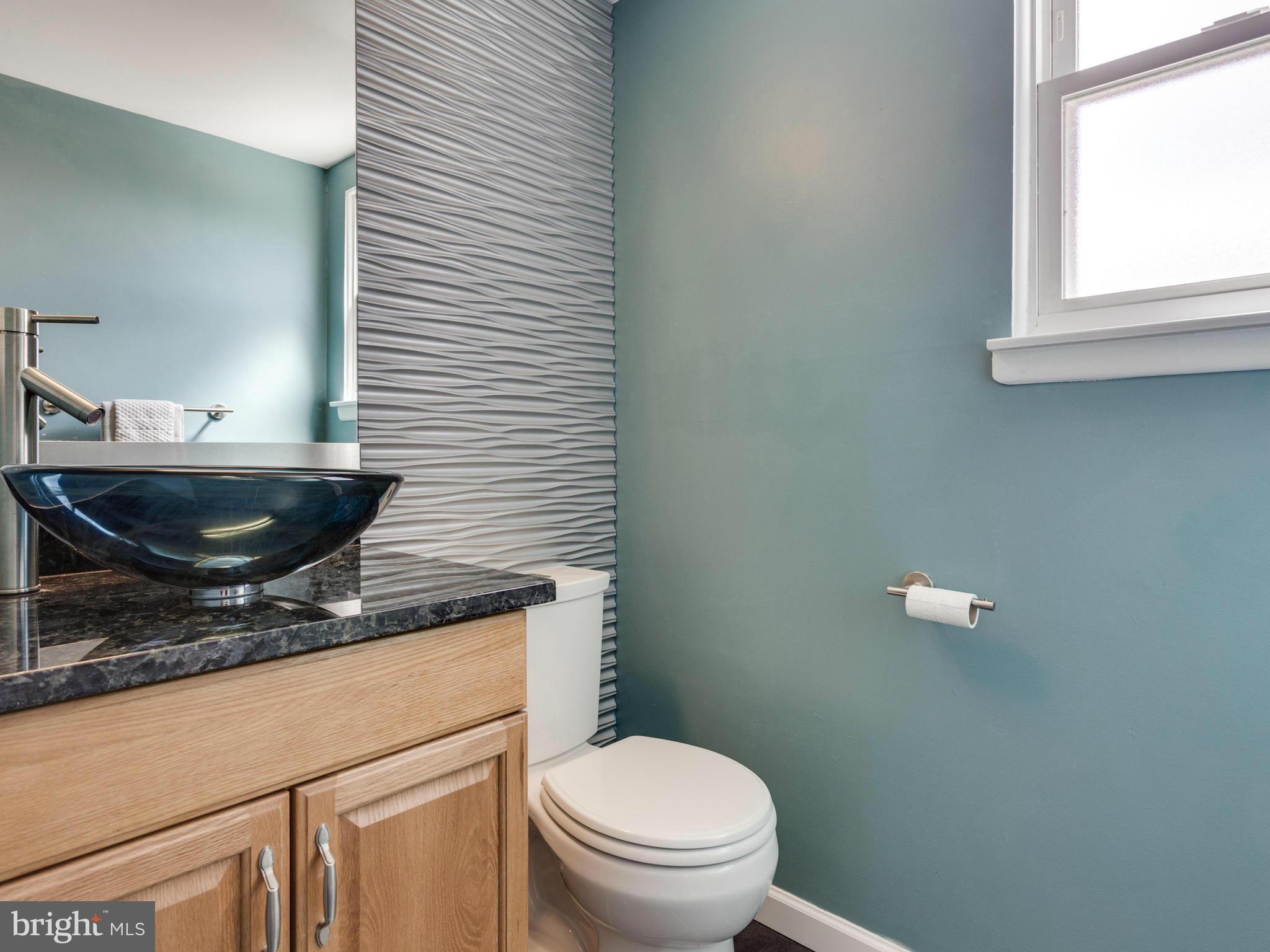 7604 Chancellor Way Springfield, VA 22153 - Photo 8 of 30 a bathroom with a granite countertop toilet a sink and a window