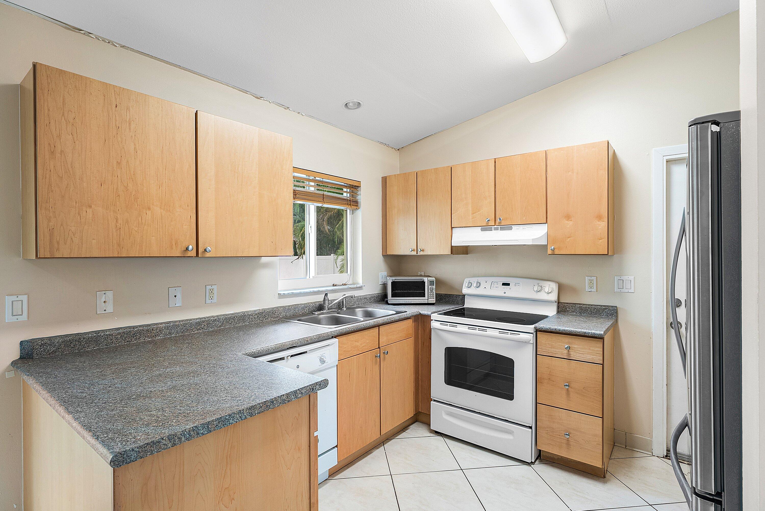 165 Northwest 8th Street Boca Raton, FL 33432 - Photo 12 of 42 a kitchen with a sink stove and cabinets