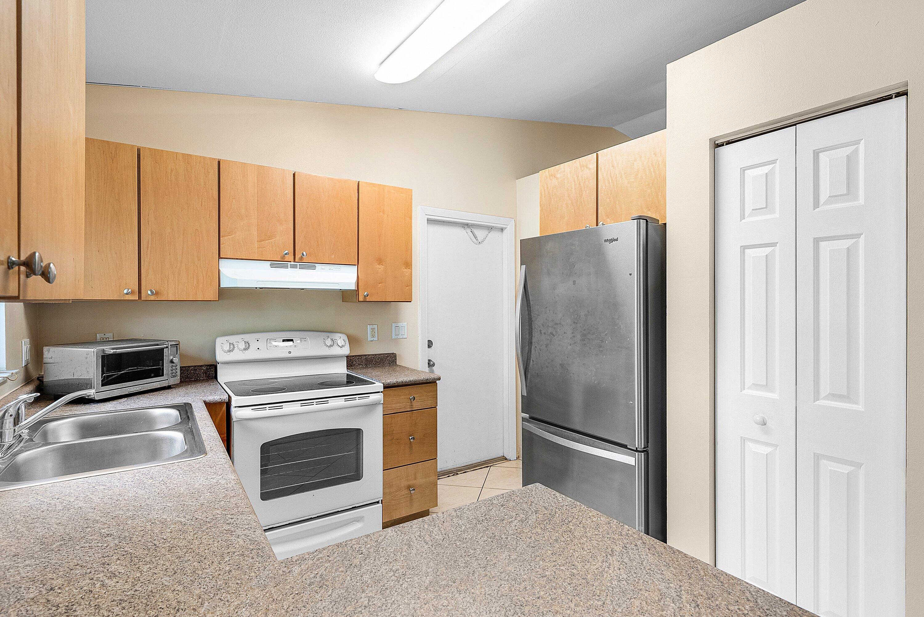 165 Northwest 8th Street Boca Raton, FL 33432 - Photo 14 of 42 a kitchen with stainless steel appliances granite countertop a refrigerator stove and sink