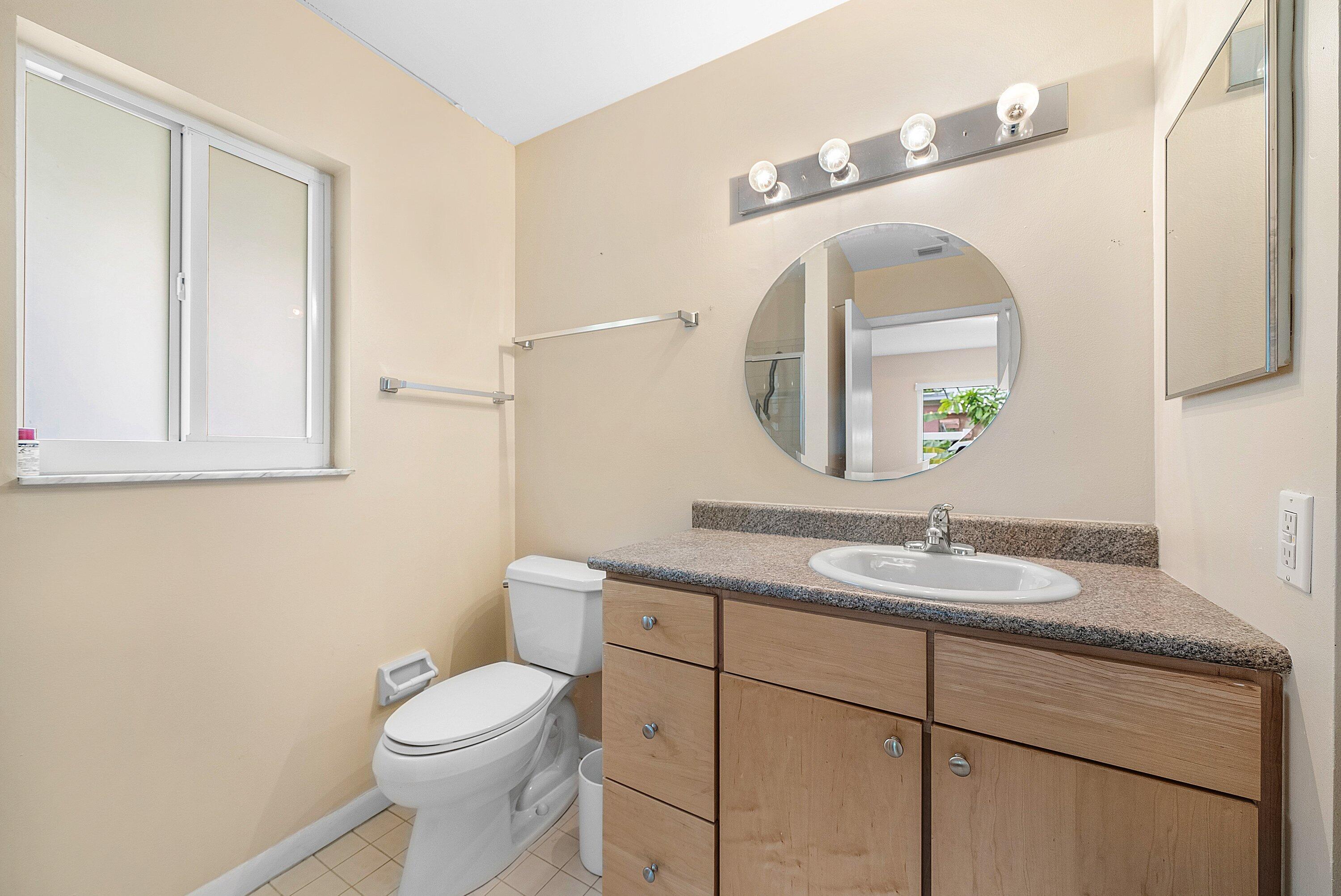 165 Northwest 8th Street Boca Raton, FL 33432 - Photo 16 of 42 a bathroom with a granite countertop toilet sink and mirror