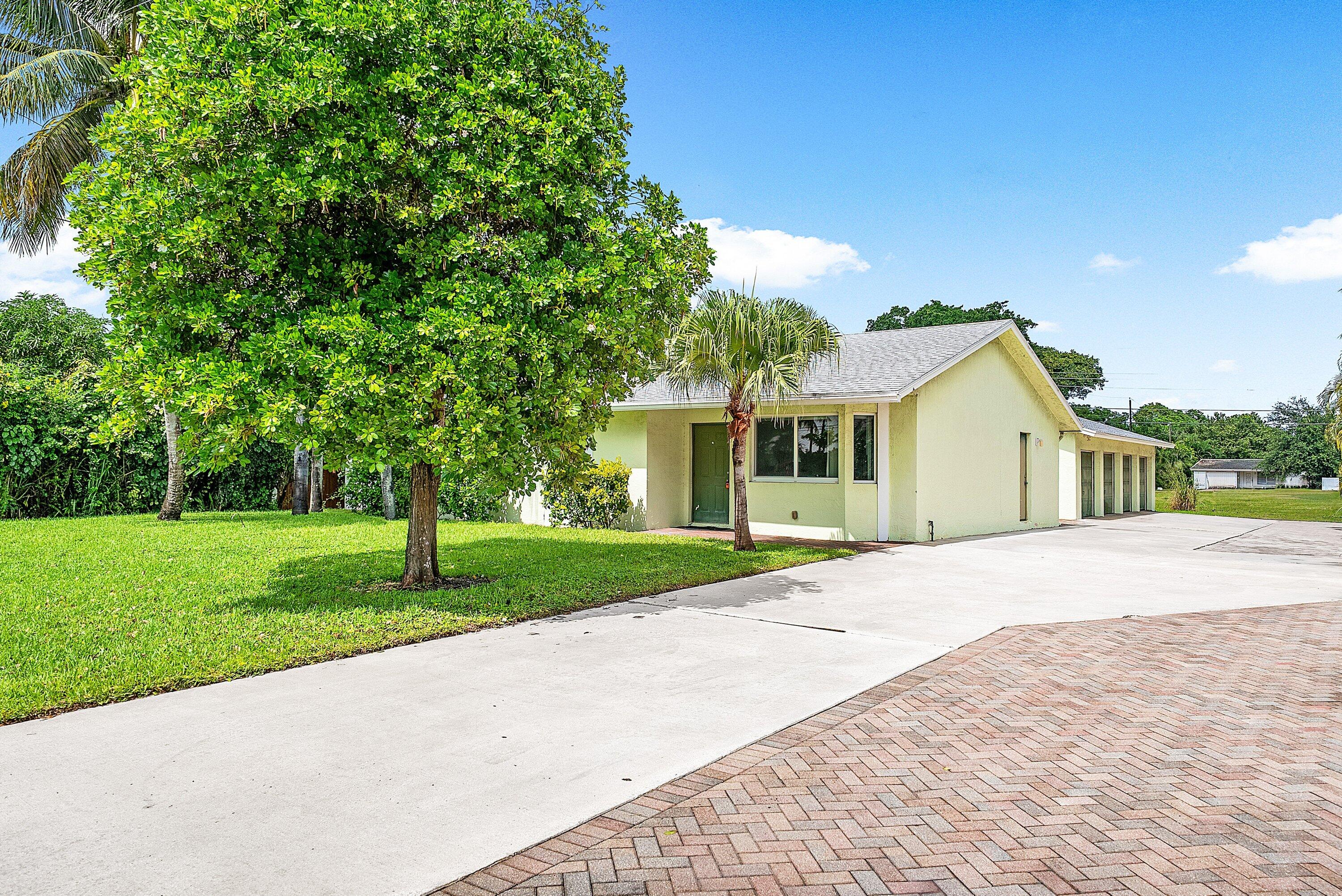 165 Northwest 8th Street Boca Raton, FL 33432 - Photo 33 of 42 a front view of a house with a yard and garage