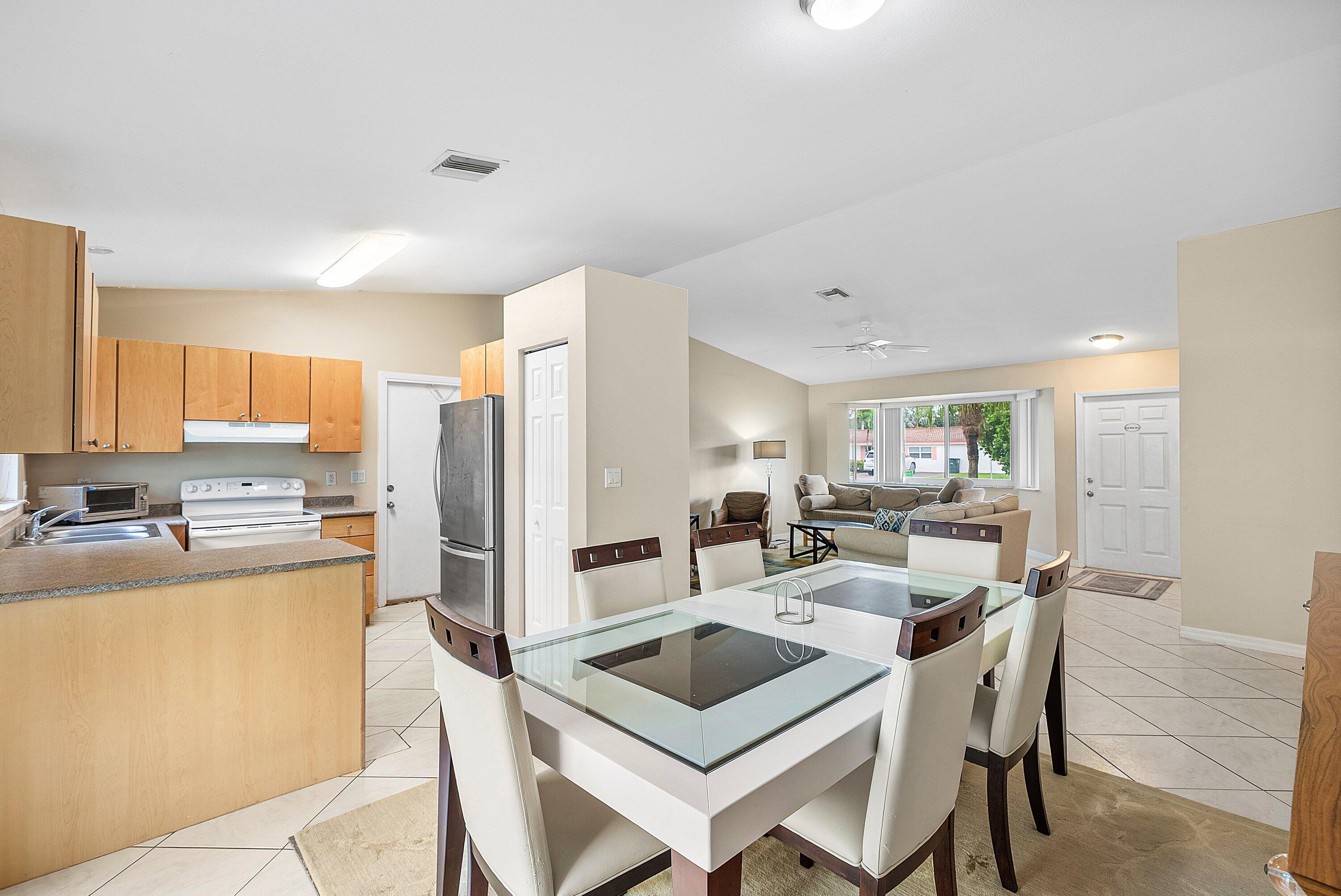 165 Northwest 8th Street Boca Raton, FL 33432 - Photo 10 of 42 a kitchen with a refrigerator a stove a sink dishwasher with a dining table and chairs